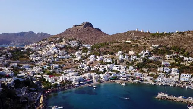 August 2017: Aerial drone video from picturesque village of Panteli with view to iconic fortified castle and windmills uphill, Leros island, Dodecanese, Greece