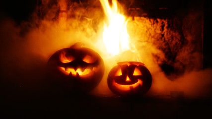 Creepy halloween pumpkins near a fireplace. Fire and smoke on the background.
