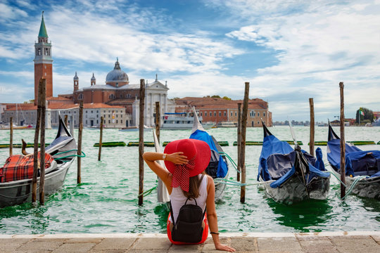 Attraktive Touristin mit rotem Hut genießt die Aussicht vom Markusplatz in Venedig, Italien