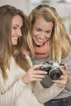 Attractive girls taking selfie picture with vintage camera