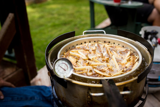 French Fries Boiling In Deep Fryer Grease At A Backyard Bbq