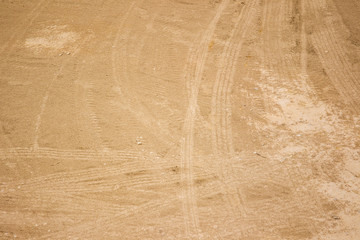 Photograph of red soil with heavy tire scratch on surface.