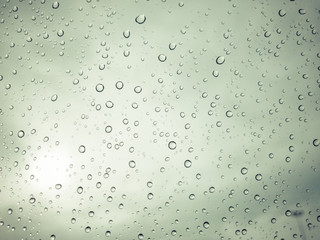 Photograph of raindrop on clear glass close up.