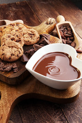 Chocolate cream melted and chocolate pieces on wooden table