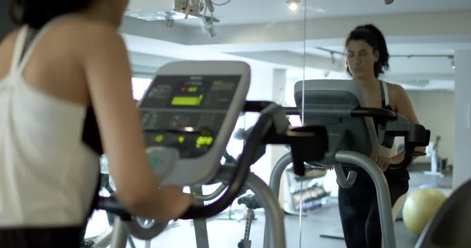 A young woman runs on an elliptical machine in the gym