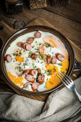 Tasty cooked egg with chopped sausages.