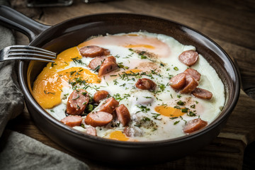 Tasty cooked egg with chopped sausages.