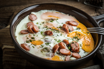 Tasty cooked egg with chopped sausages.