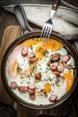 Tasty cooked egg with chopped sausages.