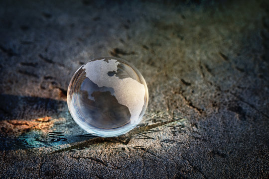Earth glass on blurred rock background, Find the right direction for our world concept