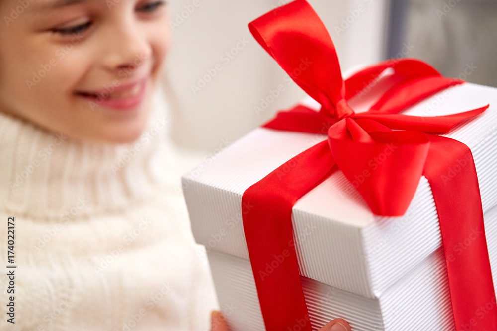 Wall mural girl with christmas gift sitting on sill at home