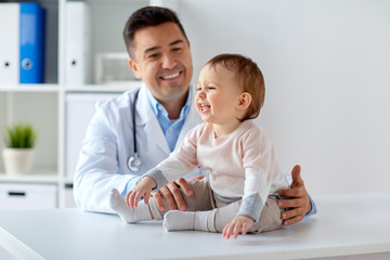 happy doctor or pediatrician with baby at clinic - obrazy, fototapety, plakaty