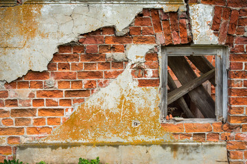 Brick wall with peeling plaster and wooden window