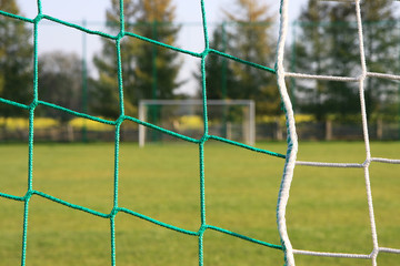 Football net on goal behind back view on field