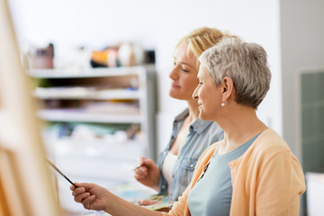 artists discussing painting on easel at art school
