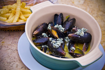 Baked mussels casserole with white wine and roquefort cheese