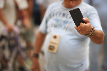 A man of colorful appearance takes himself off on the phone camera on the shopping street of the old city.