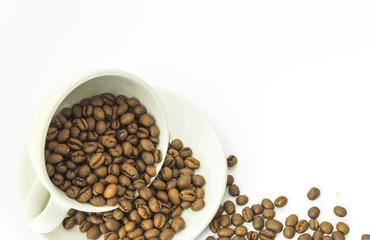 Coffee bean poured from the coffee mug on white background