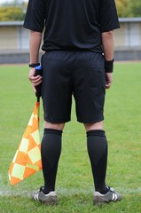 Fototapeta premium l'arbitre le long de sa ligne de touche au football