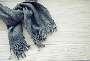 Gray scarf tied up on a wooden background, top view or flat-lay (with copy space on the right), retro style