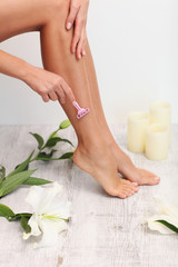 Obraz na płótnie Canvas Woman is shaving her legs.