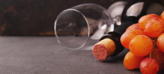 ripe grapes, red wine and a glass on a black background