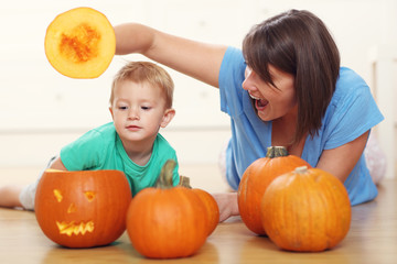Fototapeta na wymiar Mother and son preparing jack-o-lantern for Halloween