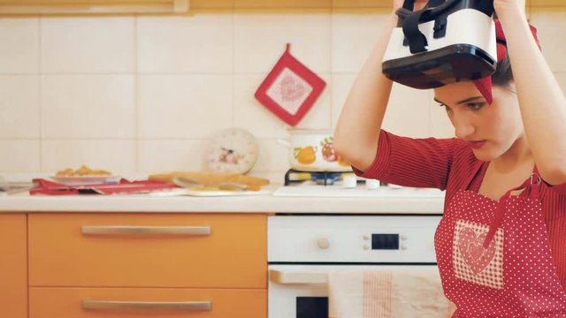 Pin-up girl uses virtual reality glasses at kitchen