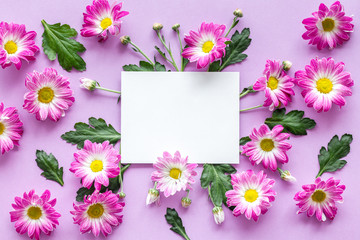 Floral mockup. Notebook among pink flowers on purple background top view