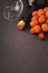 ripe grapes, red wine and a glass on a black background