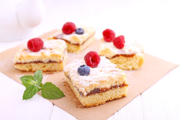 Homemade pie with berries cut into slices on a white background