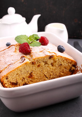 homemade cake decorated with raspberries and blueberries on a black background