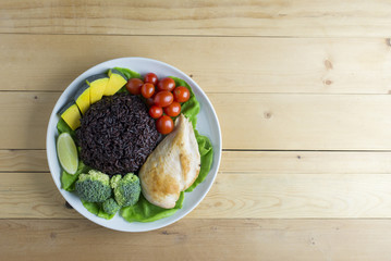 Clean food top view on woo table on disk have vegetable and chicken