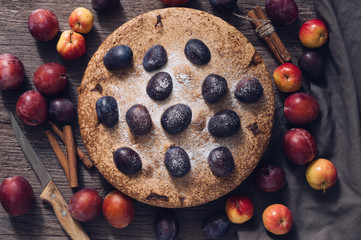 Homemade plum pie on wooden table