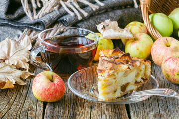 Hot tea with apples and pie on table