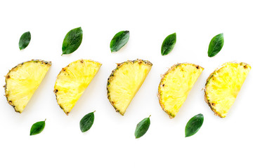 Naklejka premium Pattern of pinneapple slices and leaves on white background top view