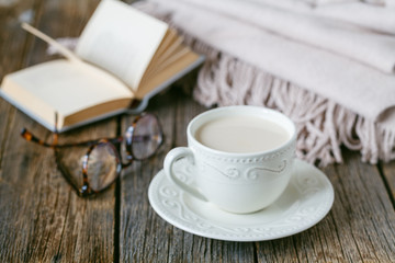 Fall evening with warm plaid< book and hot tea with milk