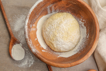 Raw dough in bowl on kitchen table