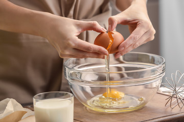 Female chef making dough in glass bowl on kitchen table