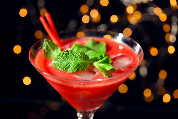 Glass of delicious strawberry daiquiri against defocused lights