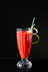 Glass of delicious strawberry daiquiri on black background