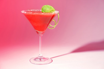 Glass of delicious strawberry daiquiri on color background