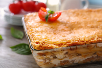 Tasty lasagna in baking dish on table, closeup