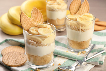 Glasses with delicious banana pudding on table