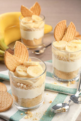 Glasses with delicious banana pudding on table