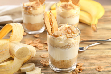 Glass with delicious banana pudding on table