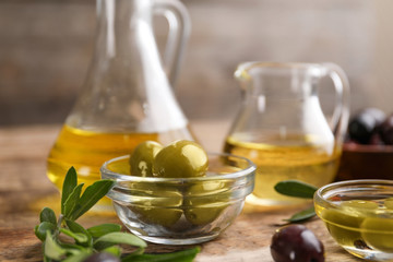 Bowl with healthy olives on wooden table