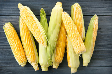Fresh corn cobs on wooden table