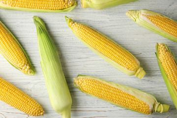 Fresh corn cobs on wooden table