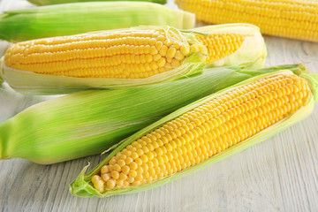 Fresh corn cobs on wooden table
